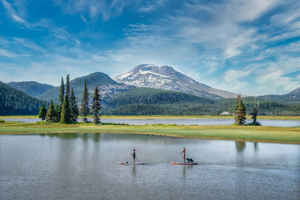 La gente y el perro disfrutan del paddle boarding en Sparks Lake — Foto de Stock