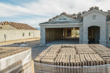 New home construction in with roof tiles in foreground