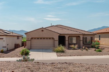 Street view of a suburban desert home with xeriscape landscaping in Southern Arizona.