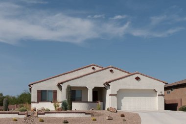 Street view of a suburban desert home with xeriscape landscaping in Southern Arizona.
