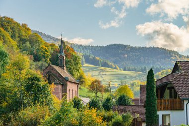 Kandertal, Almanya, Kara Orman. Gün batımında kilisesi olan güzel bir dağ manzarası. Kandertal, Almanya, Kara Orman, 