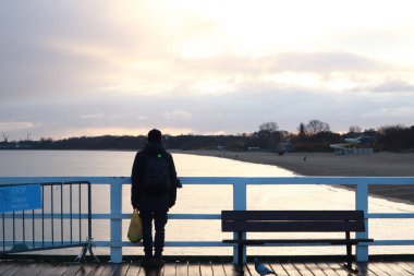 İskelenin altındaki deniz suyunun manzarası. İskelenin kolonları. Denizde iskele. Dalgalar denizin sularında. İskeleye yakın çekim.