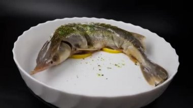 Siyah arka planda beyaz tabakta mersin balığı. Pahalı beluga pişirmek