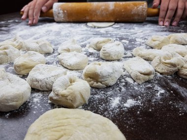 Aşçı mantov khinkali hamur köftesi pişirmek için küçük daireler çizer. Rus Tatar ve Özbek mutfağının tarifleri