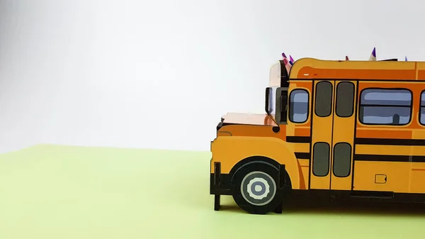 Yeşil arka planda sarı bir okul otobüsünün görüntüsü. Yakında okula gideceğim.. — Stok fotoğraf