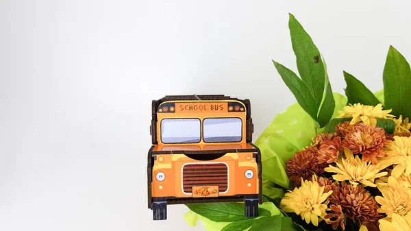 Uma Imagem Ônibus Escolar Amarelo Fundo Claro Buquê Flores Para — Fotografia de Stock