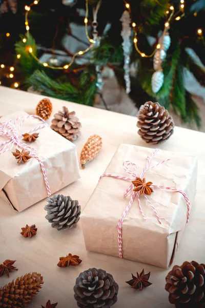 Kerstcadeaus Met Dennenappels Close Achtergrond Van Een Kerstboom Met Brandende — Stockfoto