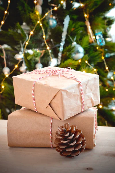 Kerstcadeaus Met Dennenappels Close Achtergrond Van Een Kerstboom Met Brandende — Stockfoto