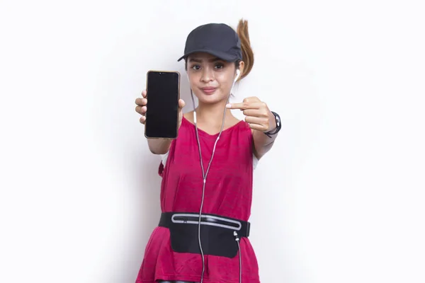 年轻的亚洲女运动员在白色背景下展示手机 — 图库照片