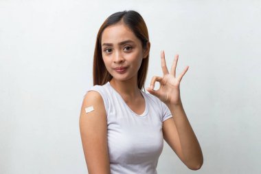 Koronavirüse karşı aşılanan Asyalı Hasta Kadın beyaz arka planda izole edilmiş Covid aşısı alıyor