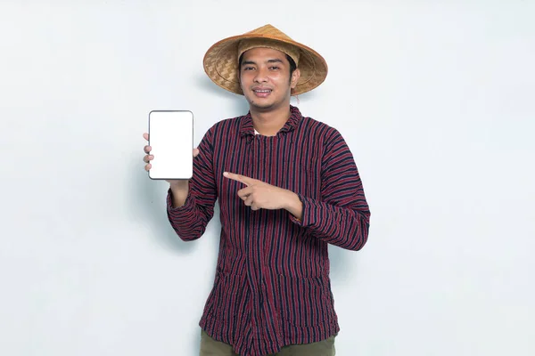 Счастливый Азиатский Фермер Демонстрирует Мобильный Телефон Изолирован Белом Фоне — стоковое фото