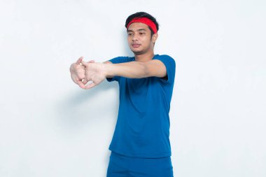 Genç Asyalı sporcu beyaz arka planda geriniyor.