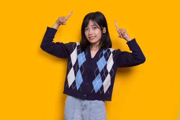 Sarı Arka Planda Farklı Yönleri Gösteren Asyalı Genç Bir Kadın — Stok fotoğraf