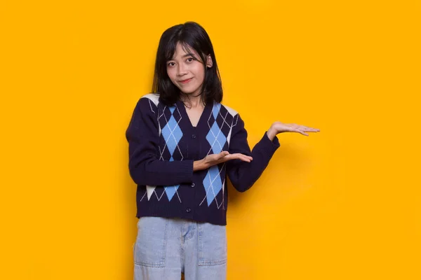 Mladá Asijská Žena Ukazuje Prsty Různých Směrů Izolovaných Žlutém Pozadí — Stock fotografie