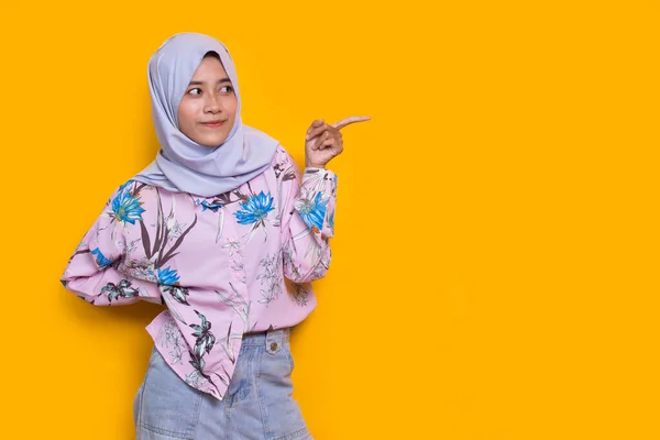 Щаслива Молода Азіатська Мусульманка Вказує Пальцями Різні Боки Ізольовані Жовтому — стокове фото
