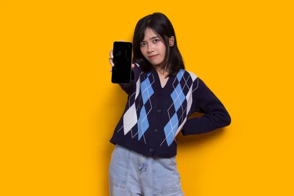 Young Beautiful Asian Woman Demonstrating Mobile Cell Phone Isolated Yellow — ストック写真