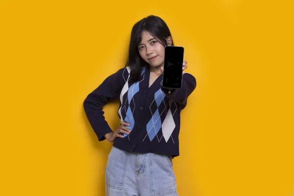 Young Beautiful Asian Woman Demonstrating Mobile Cell Phone Isolated Yellow — ストック写真