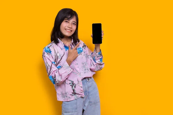 Young Beautiful Asian Woman Demonstrating Mobile Cell Phone Isolated Yellow — Foto Stock