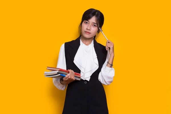 Beautiful Asian Woman Hug Book Thinking Idea Isolated Yellow Background — Stock Photo, Image