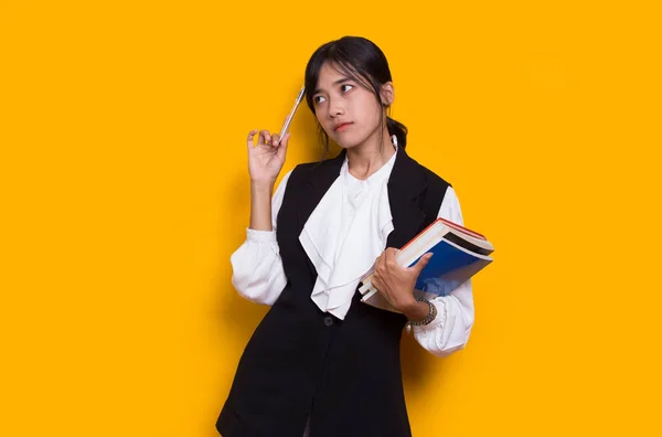 Beautiful Asian Woman Hug Book Thinking Idea Isolated Yellow Background —  Fotos de Stock