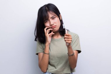 Güzel bir genç kadın diş ağrısı, diş çürüğü, diş bakımı, beyaz arka planda diş bakımı.