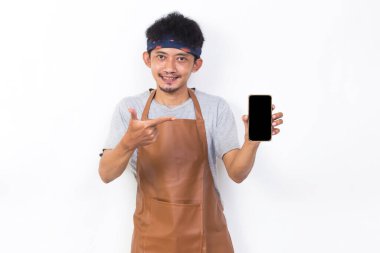 Mutlu Asyalı genç adam barmen ya da garson kız beyaz arka planda cep telefonu gösterisi yapıyor.