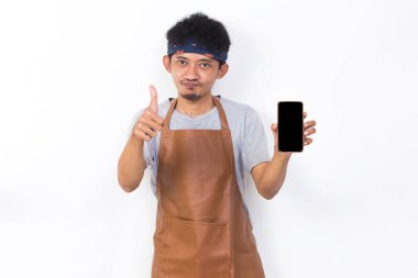 Mutlu Asyalı genç adam barmen ya da garson kız beyaz arka planda cep telefonu gösterisi yapıyor.