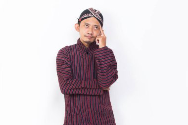 asian man with javanese traditional cloth lurik thinking idea isolated on white background