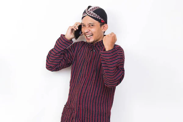 Happy Joyful Asian Man Javanese Traditional Cloth Lurik Using Mobile — Stock fotografie