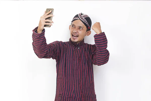 Happy Joyful Asian Man Javanese Traditional Cloth Lurik Using Mobile — Photo