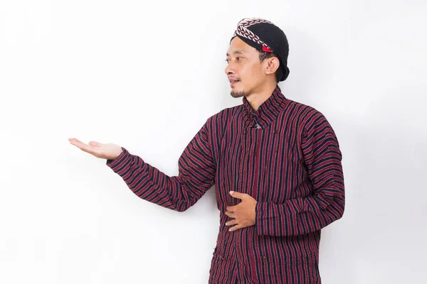 Asian Man Javanese Traditional Cloth Lurik Pointing Fingers Different Directions — Stockfoto