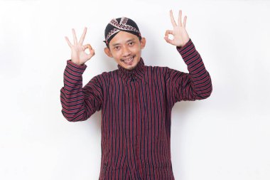 asian man with javanese traditional cloth lurik with ok sign gesture tumb up isolated on white background