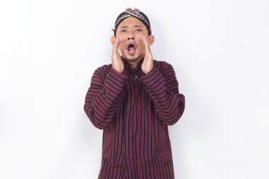 asian man with javanese traditional cloth lurik shouting and yelling announcing isolated on white background