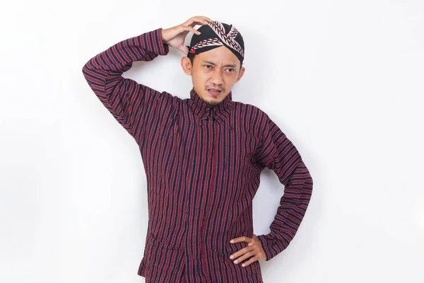 asian man with javanese traditional cloth lurik with headache on white background