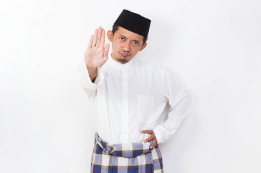 asian muslim man portrait doing stop sign with serious expression defense gesture isolated on white background