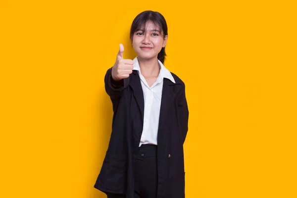 young asian beautiful woman with ok sign gesture tumb up isolated on yellow background