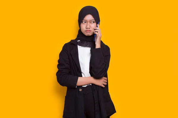 怒っとショック若いアジアのイスラム教徒のビジネス女性を黄色の背景に隔離された携帯電話を使用して — ストック写真