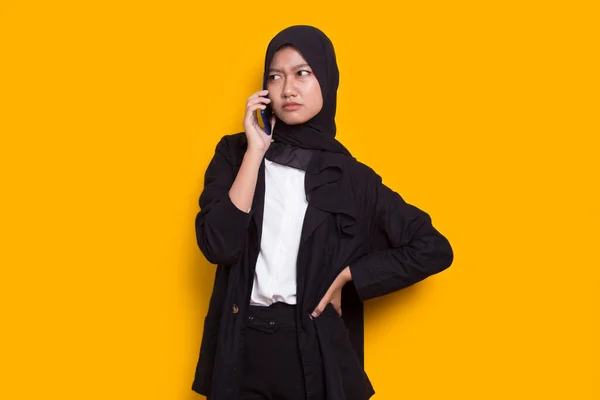 怒っとショック若いアジアのイスラム教徒のビジネス女性を黄色の背景に隔離された携帯電話を使用して — ストック写真