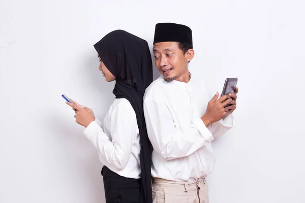 Ung Asiatisk Muslimsk Par Spionage Kigge Smartphone Isoleret Hvid Baggrund - Stock-foto