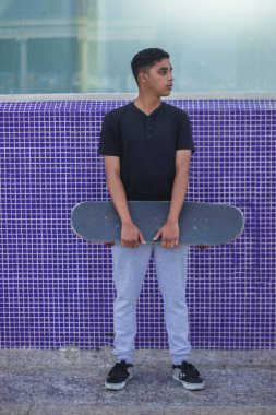 Latin genç adam kaykayla poz veriyor..