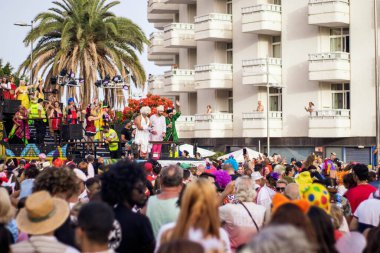 Maspalomalar, İspanya - 18 Mart 2022: Karnaval içinde bir grup insan ve arka planda bir şamandıra.