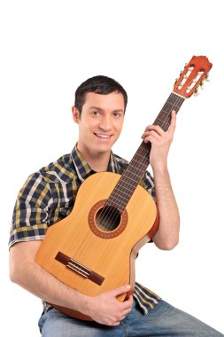 Adam akustik gitar çalıyor.