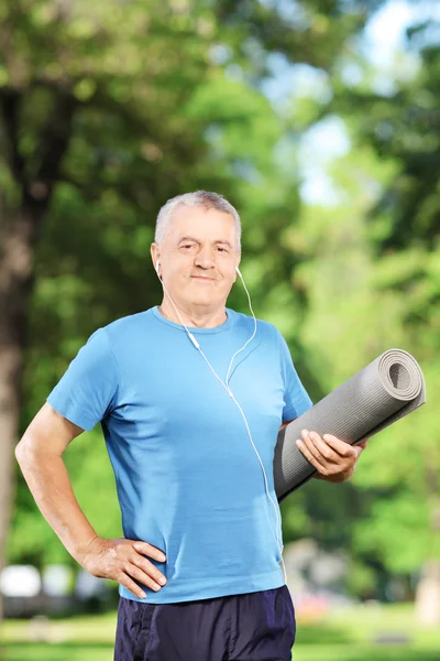 Mature man holding exercising mat — Stock Photo, Image