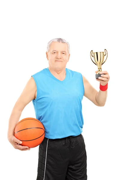 Athlete holding basketball and trophy — Stock Photo, Image