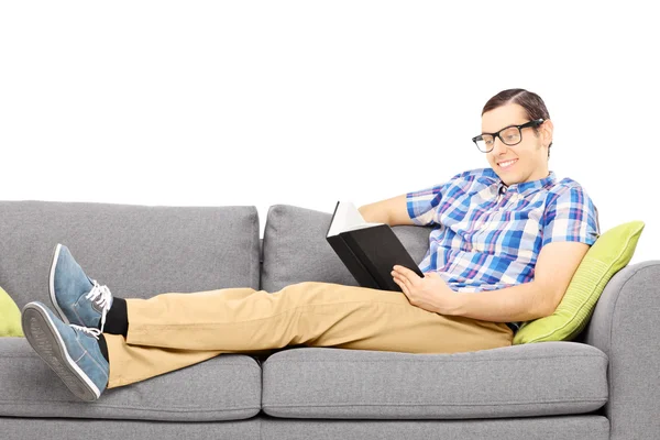 Männchen auf der Couch beim Lesen eines Buches — Stockfoto