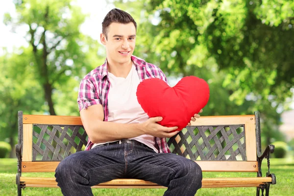 Smiling guy holding red heart