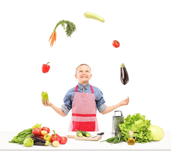 앞치마는 샐러드를 준비 하는 동안 야채와 함께 저글링 소년 — 스톡 사진