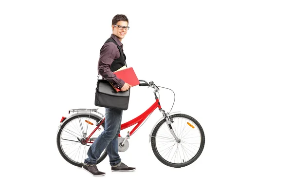 Student holding books and pushing bike — Stock Photo, Image
