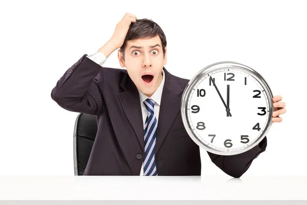 Shocked man holding a clock — Stock Photo, Image