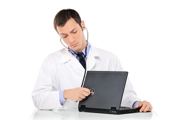 Компьютерный врач осматривает ноутбук — стоковое фото